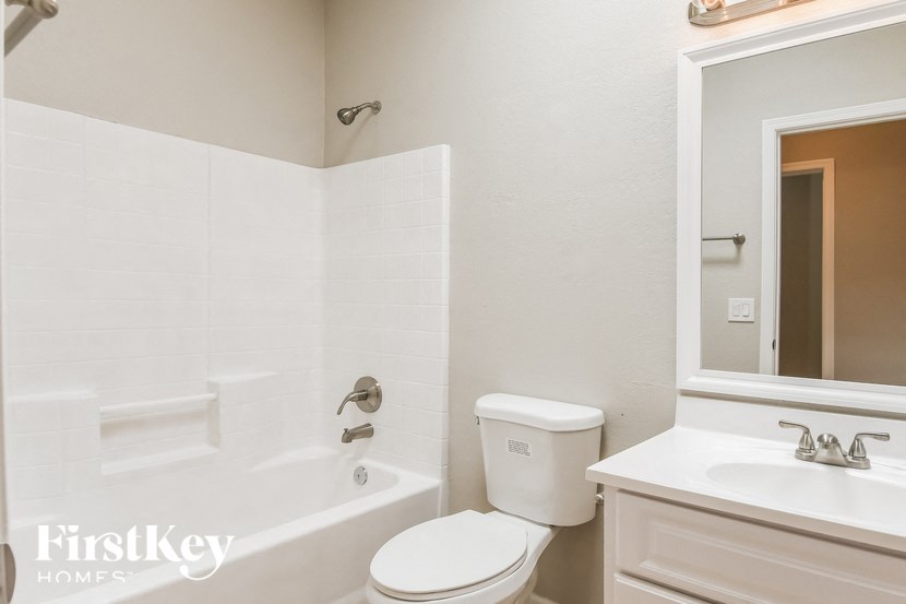 a bathroom with a toilet sink and tub and a mirror
