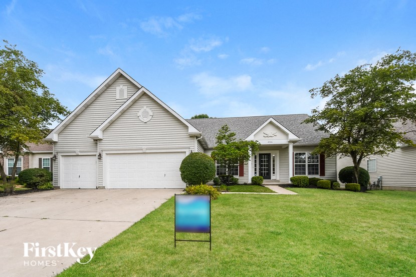 a white house with a blue sign in front of it