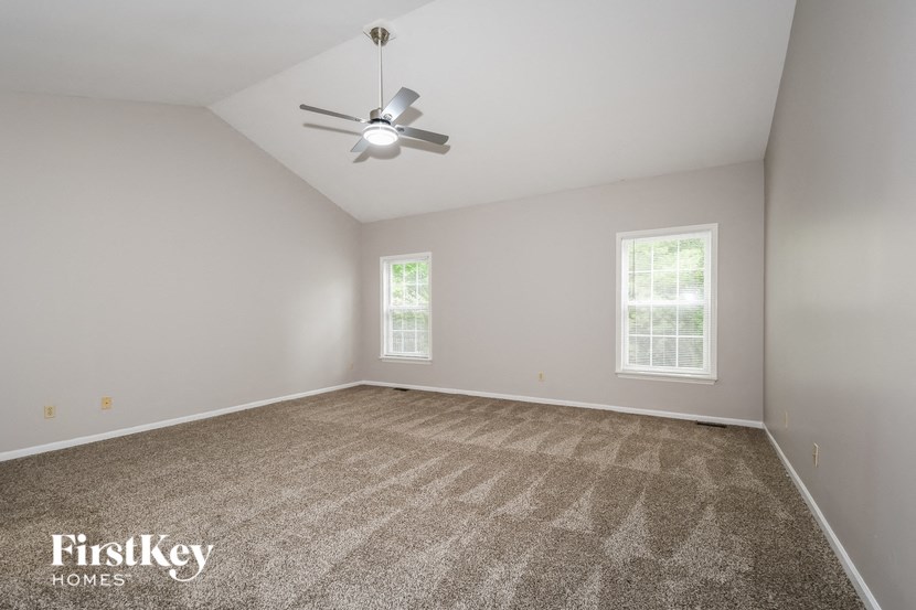 a room with carpet and a ceiling fan
