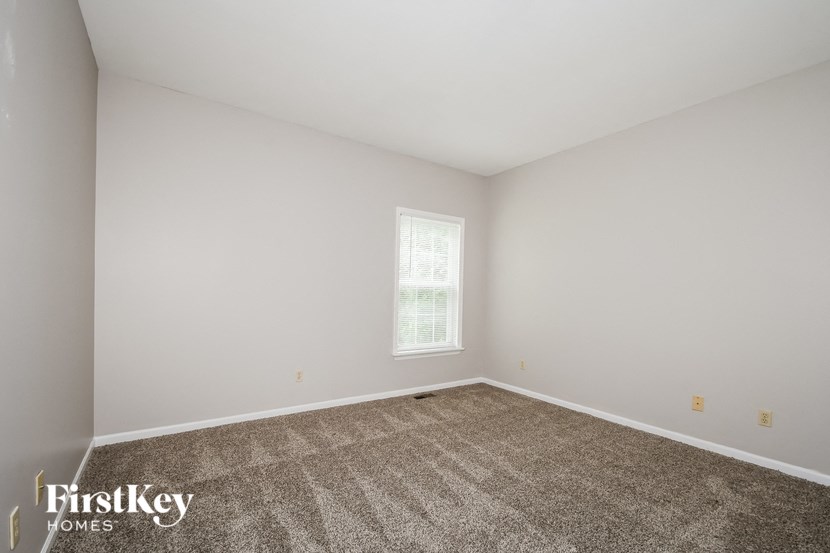 a white room with carpet and a window