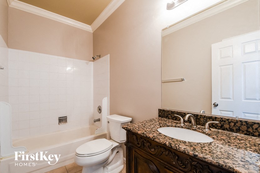 a bathroom with a toilet and a sink and a mirror
