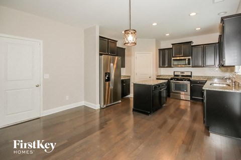 a large kitchen with black cabinets and stainless steel appliances