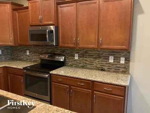 A kitchen with wooden cabinets and a granite countertop.