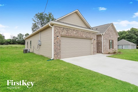 a brick house with a garage and a driveway