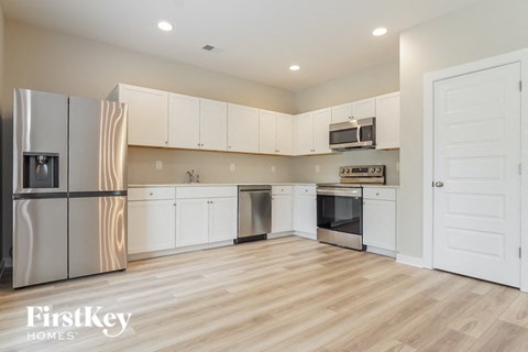 a kitchen with white cabinets and stainless steel appliances
