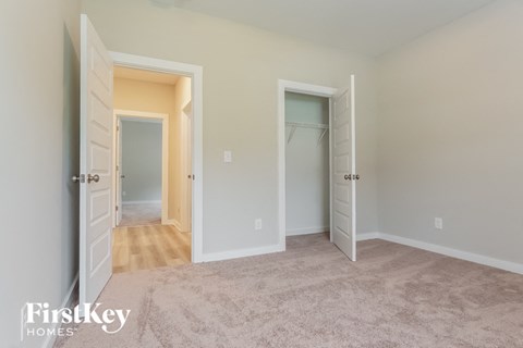 a master bedroom with two closets and a carpeted floor