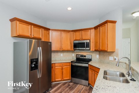 A kitchen with wooden cabinets and a stainless steel refrigerator.