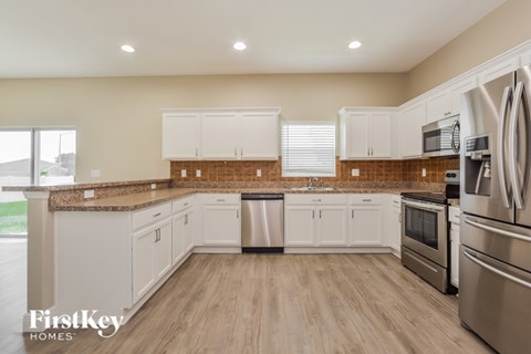 A kitchen with white cabinets and stainless steel appliances.