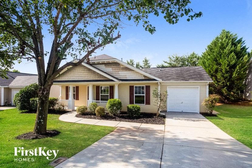 a small yellow house with a tree in front of it