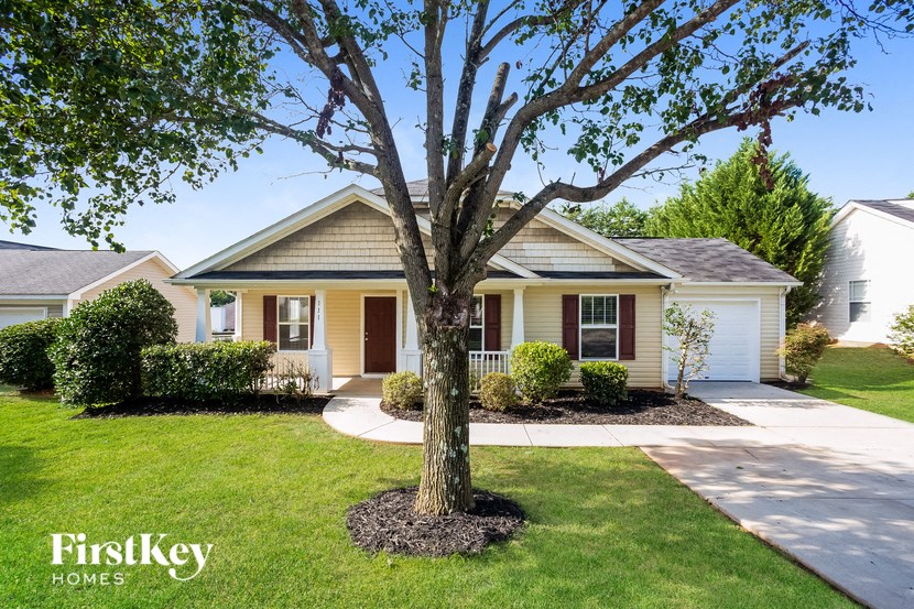 a home with a large tree in front of it