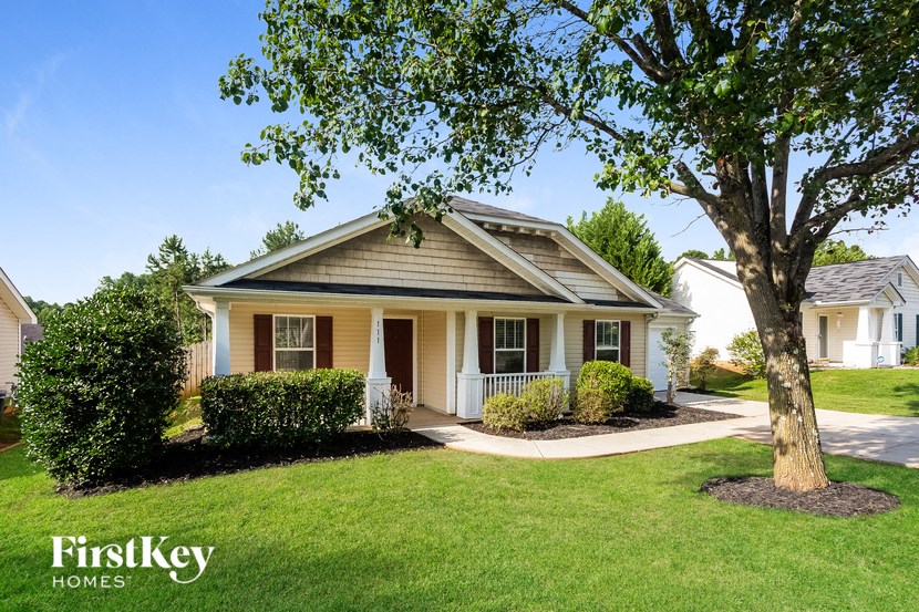 a small white house with a tree in front of it