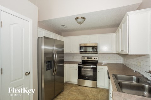 a kitchen with stainless steel appliances and white cabinets