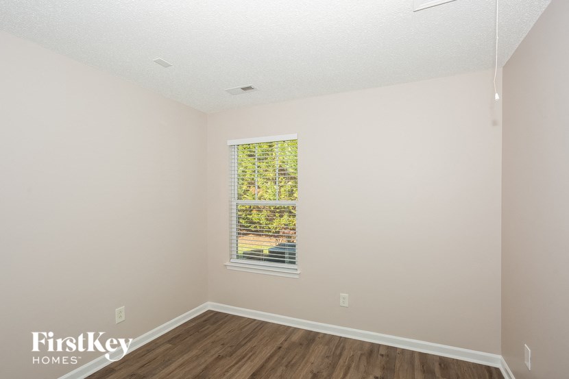 the living room of a home with wood floors and a window