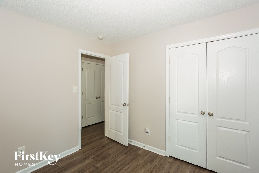 a bedroom with three white doors and a door to a closet