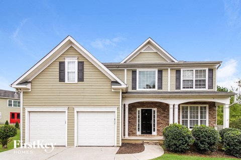 a beige house with white garage doors