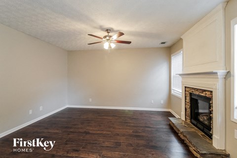 a living room with a fireplace and a ceiling fan