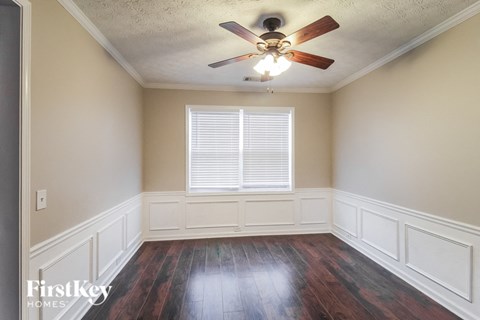 an empty room with a ceiling fan and a window