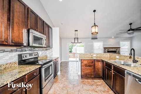 A kitchen with brown cabinets and a tiled floor.