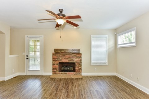 A room with a fireplace and a ceiling fan.