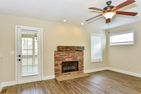 A room with a fireplace and a ceiling fan.