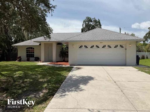 A house with a garage and a driveway in front of it.