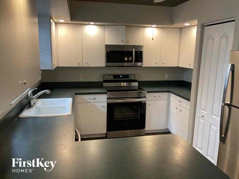 A kitchen with a stove top oven and a microwave above it.