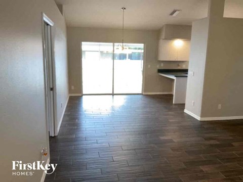 A room with wooden flooring and a sliding glass door leading to a balcony.