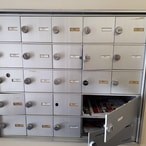 A metal filing cabinet with drawers and a shelf.