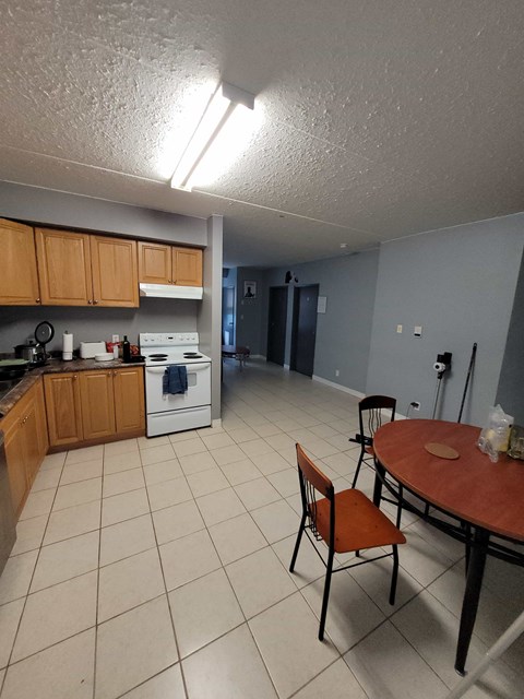 A kitchen with a table and chairs.