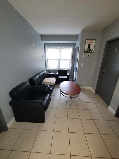 Living room with black couches and a round table.