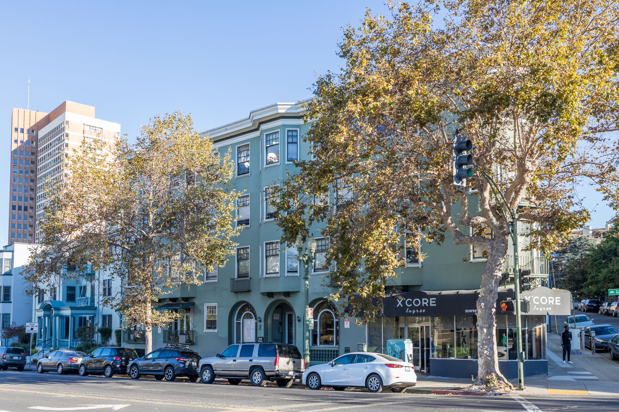 A street view of a city with cars parked on the side of the road.