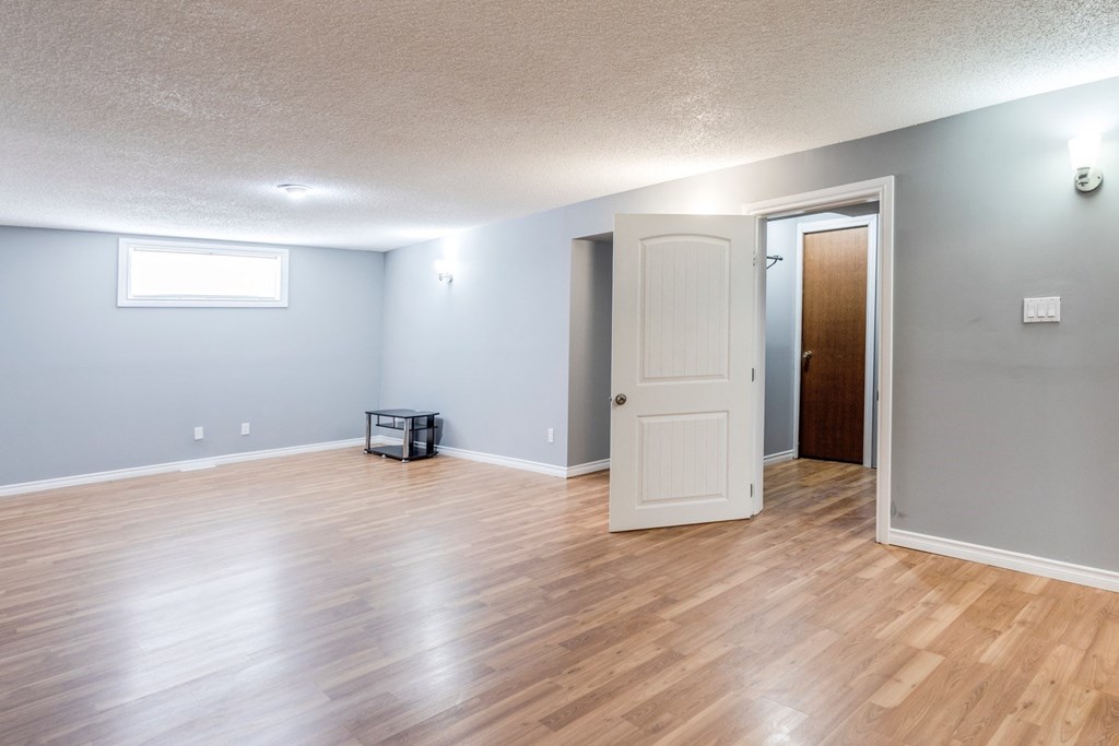 an empty living room with wood floors and a white door