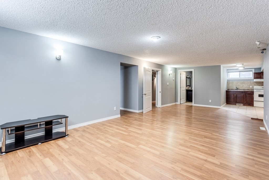 an empty living room with a hard wood floor and blue walls
