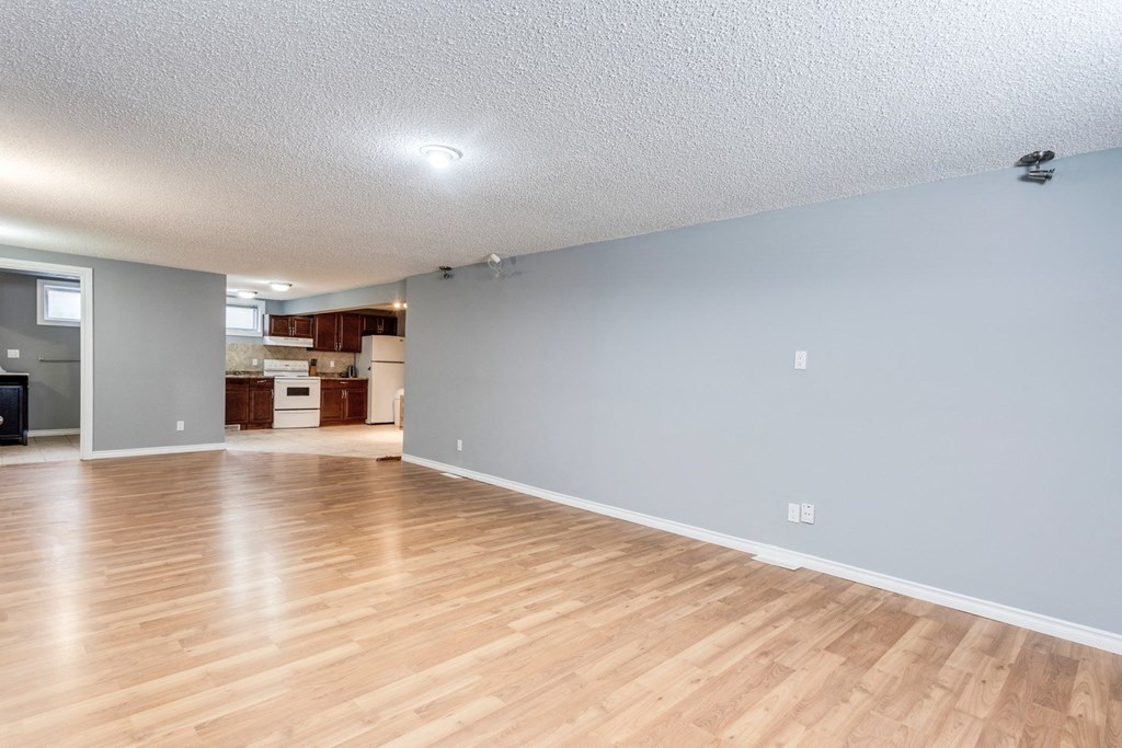 the living room and kitchen of an empty house with wood floors