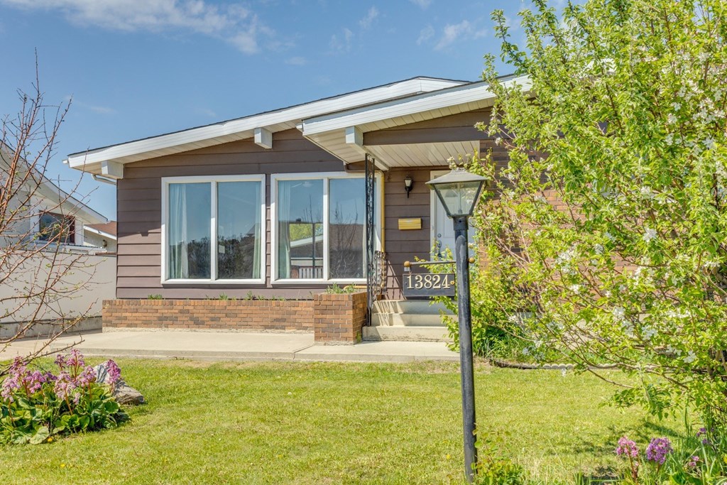 the front of a house with a yard and a lamp post