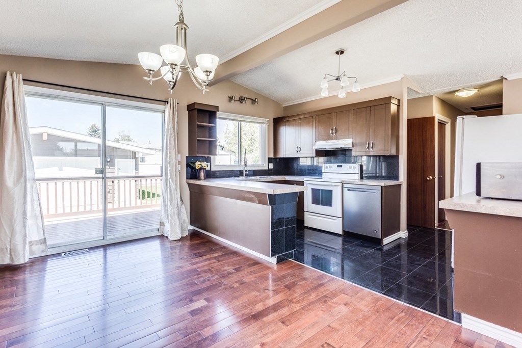 a large kitchen with a large window and a wooden floor