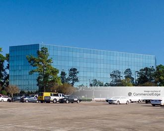 a large glass building with cars parked in front of it