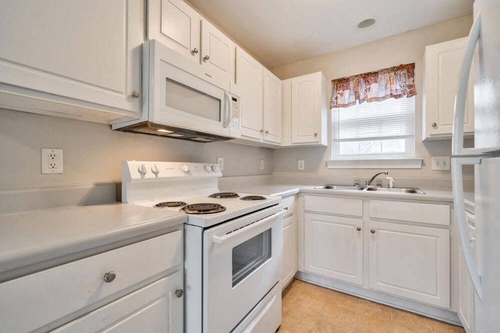 a white kitchen with white cabinets and white appliances