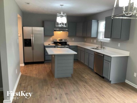 a kitchen with gray cabinets and a wooden floor