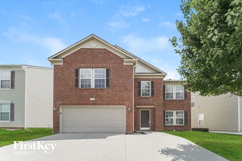 A brick house with a garage door is for sale.