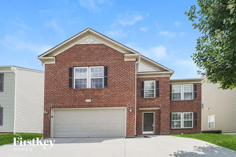 A brick house with a garage door is for sale.