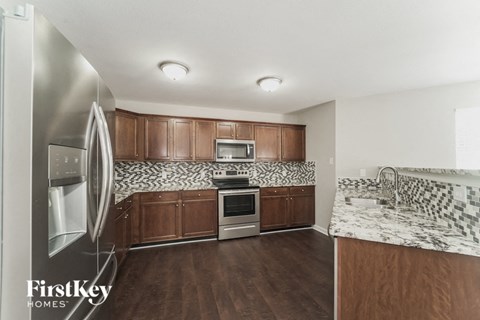 A kitchen with wooden cabinets and a marble countertop.