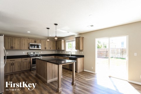 A kitchen with wooden cabinets and a black countertop.