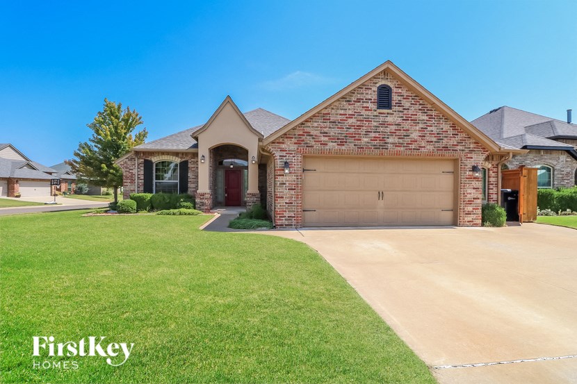 A brick house with a garage door is for sale.