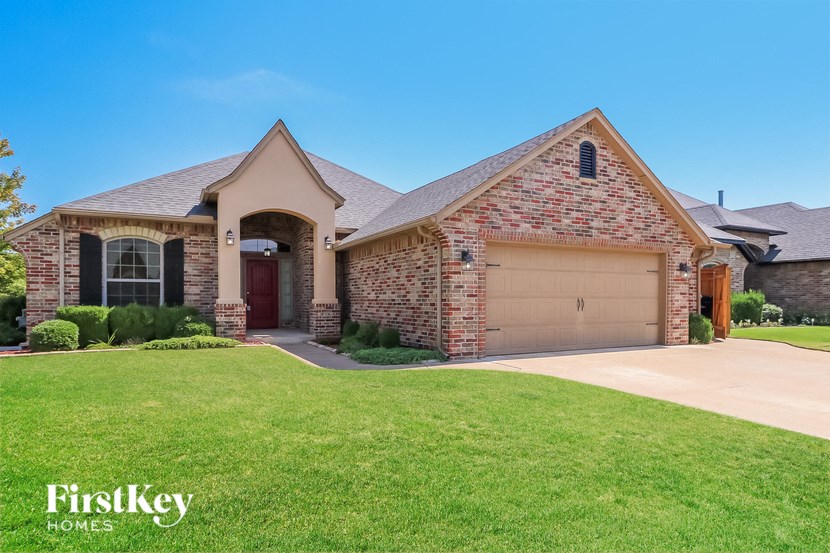 A brick house with a garage door and a window.