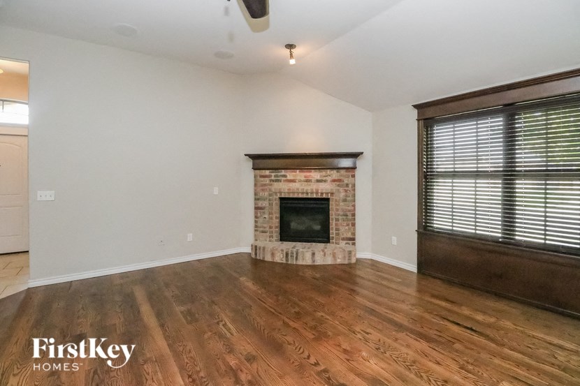 A room with a fireplace and wooden floors.