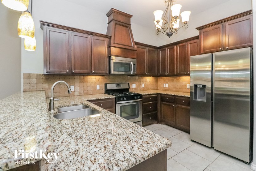 A kitchen with granite countertops and stainless steel appliances.