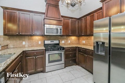 A kitchen with wooden cabinets and a stainless steel refrigerator.
