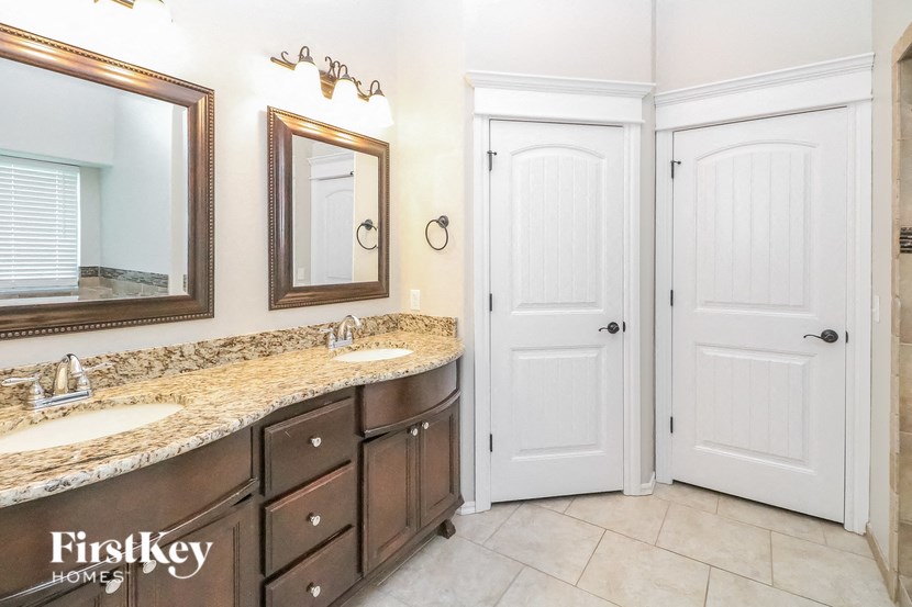 A bathroom with a double sink vanity and a mirror above it.