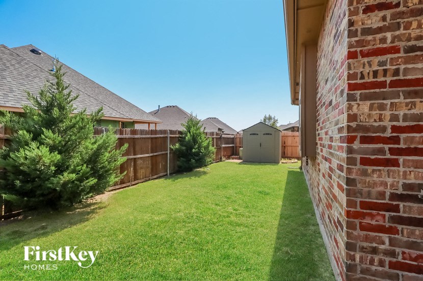 A backyard with a green lawn and a fence.